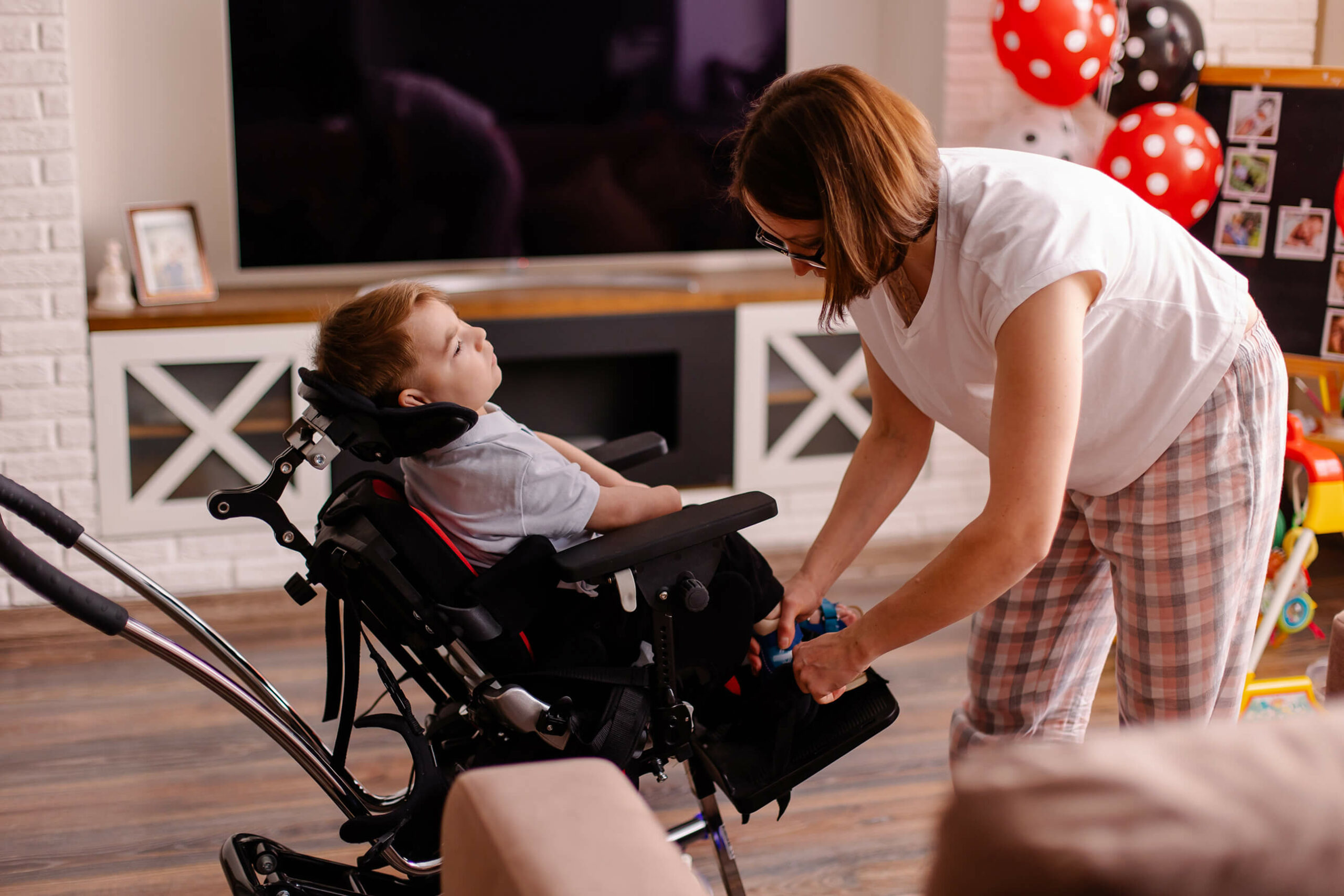 Ein Kleinkind im Rollstuhl mit einer Pflegekraft